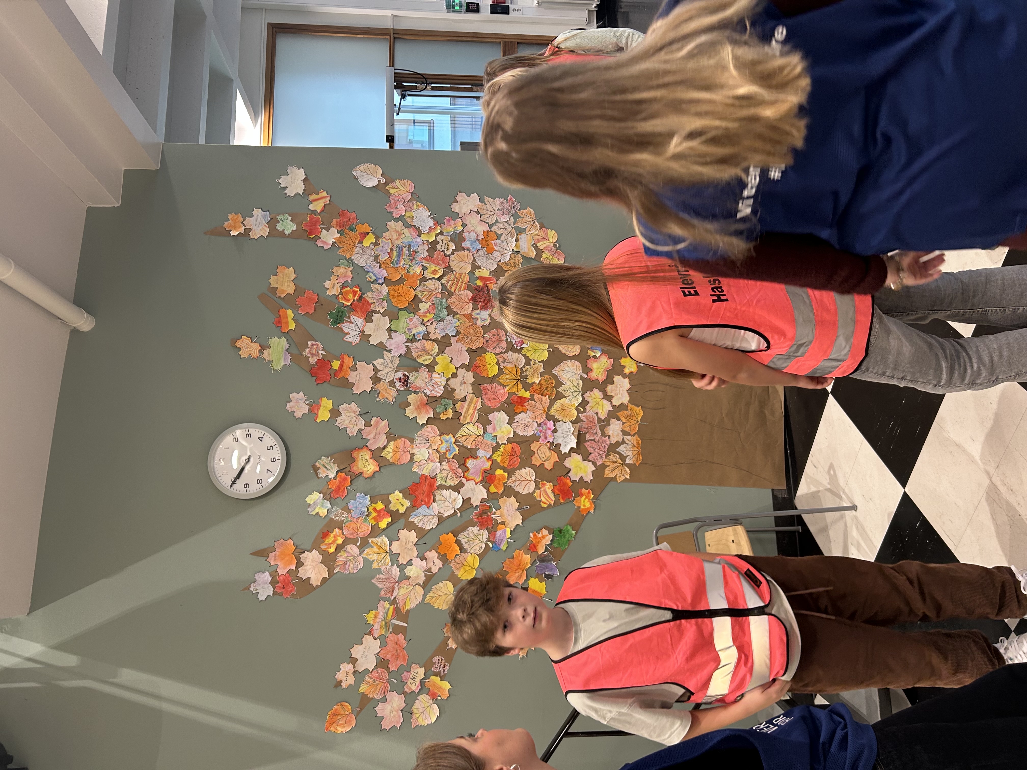 en gruppe mennesker som står foran et dekorert tre