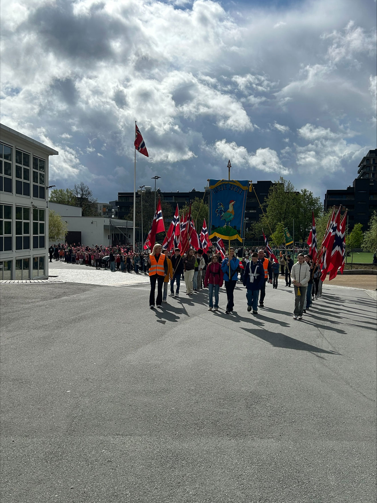 en gruppe mennesker som går på en gate med flagg